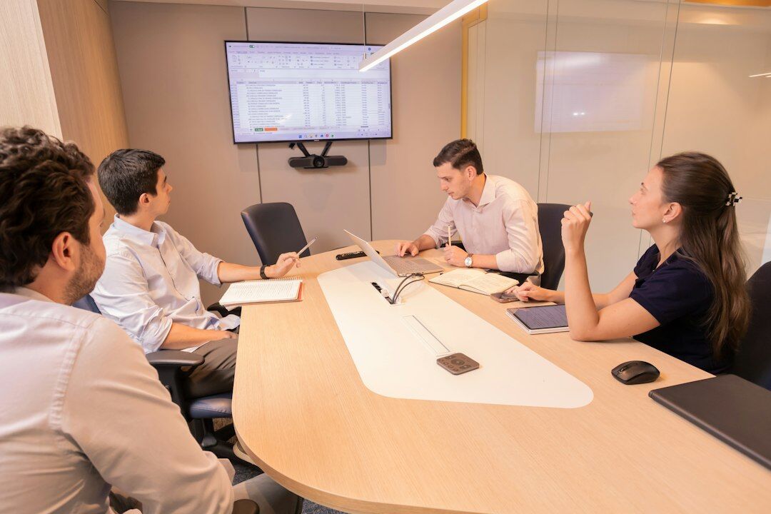 Empty corporate boardroom with a long table and closed blinds